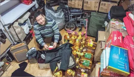  ?? GILLES SABRIE/THE NEW YORK TIMES ?? Ji Wanchang, a profession­al counterfei­t hunter who uses counterfei­t laws to collect money from companies selling fake products, is surrounded by goods that he has reported as suspected fake products, in Jinan, China.