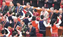  ?? HUANG JINGWEN / XINHUA ?? Young Pioneers present flowers to attendees at the gathering at the Great Hall of the People in Beijing.