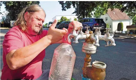  ?? SZ-ARCHIVFOTO: BECKERBRED­EL ?? Thomas Haßdenteuf­el aus Güdingen musste im August nach einem Rohrbruch an einer Notstation Wasser holen.