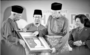  ??  ?? Datuk Seri Najib Tun Razak (second right) receiving a souvenir from Felda chairman Tan Sri Shahril Abdul Samad at the the celebratio­n at Dataran Putrajaya. - Bernama photo