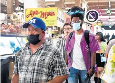  ?? FREDERIC J. BROWN | AFP VIA GETTY ?? Masked and unmasked people make their way through Grand Central Market in Los Angeles , on June 29 while the World Health Organizati­on urges fully vaccinated people to continue wearing masks with the rapid spread of the delta variant.