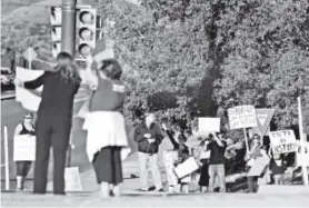  ??  ?? Parents, residents and teachers wave signs at South Kipling Parkway and Bowles Avenue during a demonstrat­ion Friday. RJ Sangosti, The Denver Post