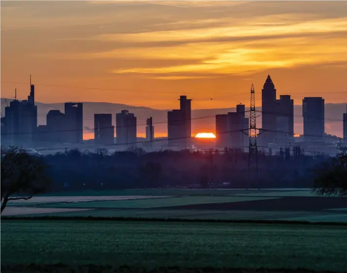  ?? ?? The sun rises behind the buildings of the banking district in Frankfurt, Germany, Tuesday, December 27, 2022. Photo: Associated Press/Michael Probst.