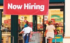  ?? AFP ?? A ‘Now Hiring’ sign hangs near the entrance of a Winn-Dixie Supermarke­t in Hallandale, Florida. Initial claims for state unemployme­nt benefits decreased 38,000 last week.