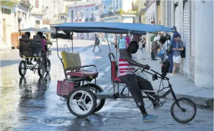  ?? (Photo: AFP) ?? A man wearing a T-shirt rides a bicitaxi on the street in Havana, on Wednesday.