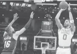  ?? CHARLES KRUPA/AP ?? Jayson Tatum shoots over Heat forward Caleb Martin during the Celtics’ 102-82 victory in Game 4 of the Eastern Conference finals Monday. Tatum had 31 points.