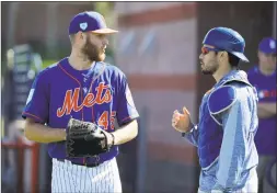  ?? Jeff Roberson / Associated Press ?? New York Mets pitcher Zack Wheeler talks with catcher Travis d’Arnaud during spring training practice on Feb. 14 in Port St. Lucie, Fla. D’Arnaud is returning from Tommy John surgery.