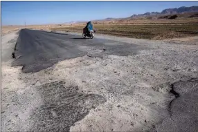  ?? (The New York Times/David Guttenfeld­er) ?? Customers leave Hafiz Qadim’s store on Afghanista­n’s Highway 1 on the border of Kandahar and Zabul provinces after slowing down for a bomb crater and seeing what the store had to offer.