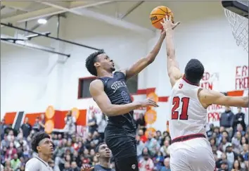  ?? Nick Koza ?? BRONNY JAMES of Sierra Canyon attempts a layup against the defense of Centennial forward Aaron McBride during the first half. James scored 13 points in Sierra Canyon’s loss in an Open Division pool-play game.