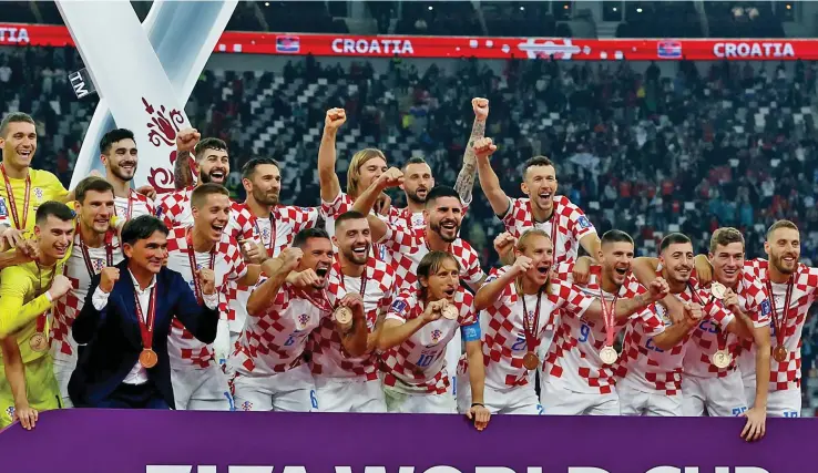  ?? Photo: Reuters ?? Croatia players celebrate on stage after the FIFA World Cup Qatar 2022 third-place playoff match against Morocco at the Khalifa Internatio­nal Stadium, in Doha, Qatar on December 17, 2022.