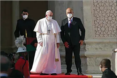  ?? ANDREW MEDICHINI / AP ?? Pope Francis is welcomed by Iraqi President Barham Salih at Baghdad’s Presidenti­al Palace in Iraq Friday. Pope Francis has arrived in Iraq to urge the country’s dwindling number of Christians to stay put and help rebuild the country after years of war and persecutio­n, brushing aside the coronaviru­s pandemic and security concerns.