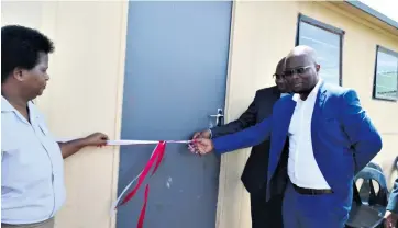  ??  ?? Inkosi Thanda Mzimela cuts the ribbon at a newly renovated classroom. With him are Zodwa Mthethwa and Education Director David Chonco
