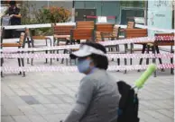  ?? ?? A woman wearing a mask sits near an open-air cafe which has been cordoned off in Seoul.