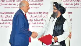  ??  ?? US Special Representa­tive for Afghanista­n Reconcilia­tion Zalmay Khalilzad and Taliban co-founder Mullah Abdul Ghani Baradar shake hands after signing a peace agreement during a ceremony in the Qatari capital Doha on Saturday