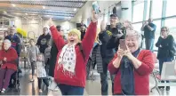  ??  ?? Triumphant welcoming . . . Otago Nuggets fans celebrate as the team walks into the Dunedin Airport terminal yesterday.