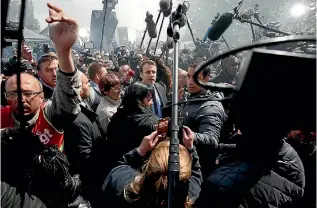  ?? PHOTO: REUTERS ?? Emmanuel Macron, centre, is surrounded by journalist­s as he arrives to meet Whirlpool employees in front of the company plant in Amiens.