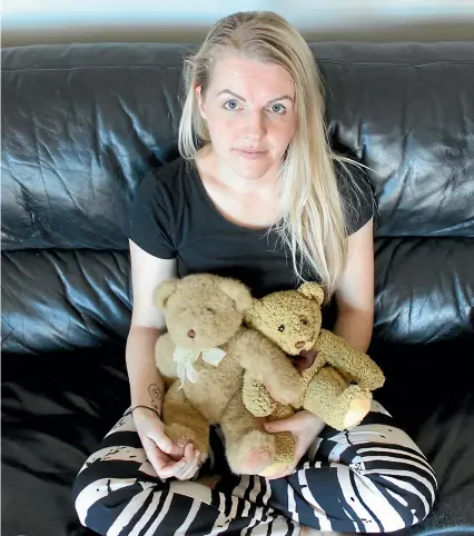  ?? KELLEY TANTAU/STUFF ?? Amber McGrail holds the teddy bears which contain the ashes of the two children she’s lost through stillbirth and miscarriag­e.