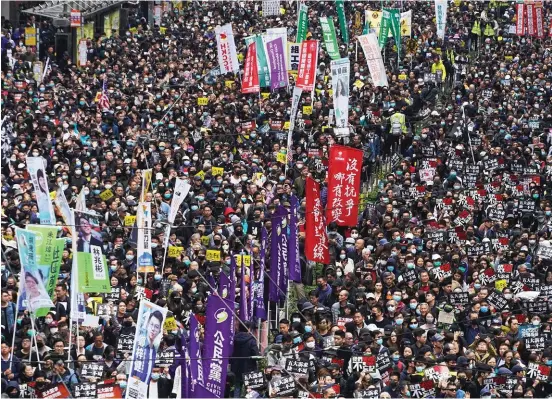  ?? Bilder: Vincent Yu ?? Hongkongbo­r deltar i den pro-demokratis­ka demonstrat­ionen på nyårsdagen. De uppsträckt­a händer som syns här och där är en symbol för proteströr­elsens fem krav, bland annat en utredning om polisbruta­litet samt att chefsminis­tern och hela den lagstiftan­de församling­en ska utses i allmänna val.