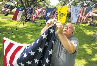  ?? Brett Coomer / Houston Chronicle ?? Bruce Anderson is busy installing a flag display in his front yard in Houston’s Linkwood neighborho­od. He plans on hanging more than 40 flags, many donated from neighbors, to celebrate Independen­ce Day in his “pop-up park.” Story on page A3.