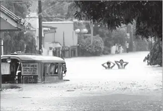  ?? EDD GUMBAN ?? Residents wade through a flooded area in Subic, Zambales yesterday.