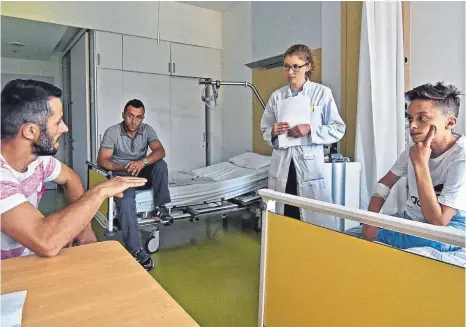  ?? ARCHIVFOTO: AXEL PRIES ?? So war’s im Mai: Endrit Shala (rechts) bewohnt in Ulm mit seinem Vater Vehid (hinten) ein Krankenhau­s-Zimmer. Der in Mietingen wohnende Onkel Fatmir spricht mit der Ärztin Dr. Katharina Kandler.