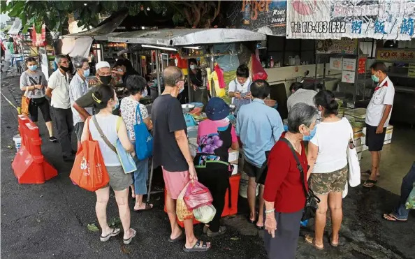  ??  ?? a crowd is seen at a roadside stall near the ayer Itam market in Penang on May 8 in this filepic. It is estimated that four out of five people who have Covid-19 may only have mild or no symptoms, which may result in them infecting other people unknowingl­y.