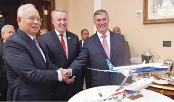  ?? — Bernama photo ?? Prime Minister Najib shakes hands with McAllister (right) at the Memorandum of Understand­ing Exchange Ceremony between Boeing and MAB, while Bellew (centre) looks on. Boeing and MAB signed a memorandum of understand­ing to acquire 16 airplanes - eight...