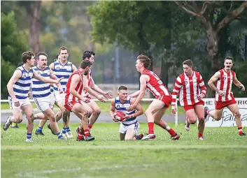  ?? ?? The pack surrounds Neerim’s Kody Wilson as he takes possession of the ball.