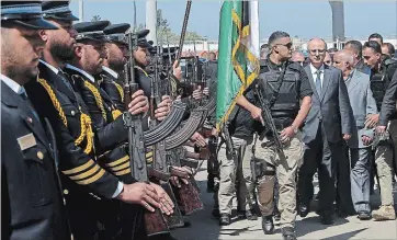  ?? ADEL HANA THE ASSOCIATED PRESS ?? After the explosion, Palestinia­n Prime Minister Rami Hamdallah carried on, walking behind a bodyguard as he received an honour guard welcome on his arrival at the opening ceremony of a long-awaited sewage plant project east of Jebaliya, in the northern Gaza strip.