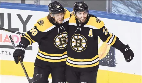  ?? Nathan Denette / Associated Press ?? The Boston Bruins’ Patrice Bergeron, right, celebrates his goal with teammate David Pastrnak during the second period in Game 5 of an Eastern Conference first-round playoff series on Wednesday in Toronto.