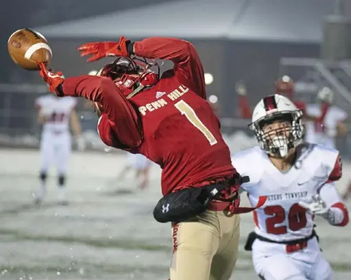  ?? Barry Reeger/ For the Post-Gazette ?? Penn Hills receiver Daequan Hardy, center, tries to secure a pass in front of Peters Township’s Adrian Williams in the WPIAL Class 5A semifinal Friday night at Norwin High School.