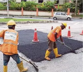  ?? PIC COURTESY OF MBSA ?? Indah Water Konsortium workers patching up the road in Shah Alam.