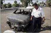  ?? KHALID MOHAMMED — THE ASSOCIATED PRESS FILE ?? On Sept. 25, 2007, an Iraqi traffic policeman inspects a car destroyed by a Blackwater security detail in al-Nisoor Square in Baghdad, Iraq.