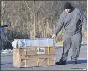  ?? JIMMY MAY — FOR THE ASSOCIATED PRESS ?? The driver of a pickup transporti­ng monkeys pulls a crate of monkeys off of the road after a crash Friday near Danville, Pa.