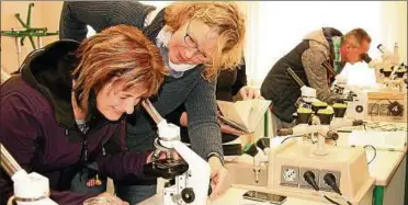  ??  ?? Biologiele­hrerin Antje Kreienbrin­k (.v.l.) zeigt Interessie­rten Präparat unter dem Mikroskop. Foto: Christiane Weber