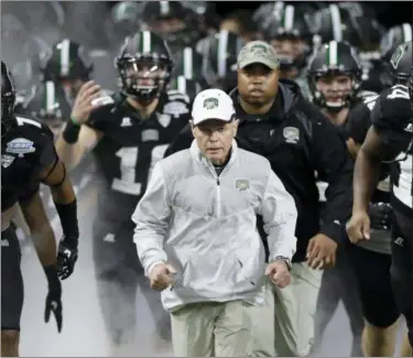  ?? ASSOCIATED PRESS FILE ?? Ohio coach Frank Solich runs out onto the field with his team before the Mid-American Conference championsh­ip game against Western Michigan in Detroit. Ohio is looking for its first league title since 1968.