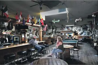  ?? Photograph­s by Brian van der Brug Los Angeles Times ?? JAKE’S SALOON owners Forrest and Sherri Newman chat inside the Lone Pine bar. “The lockdown hit us like a tornado,” said Sherri. “I felt hopeless and lost, wondering how on Earth we could pay the bills.”