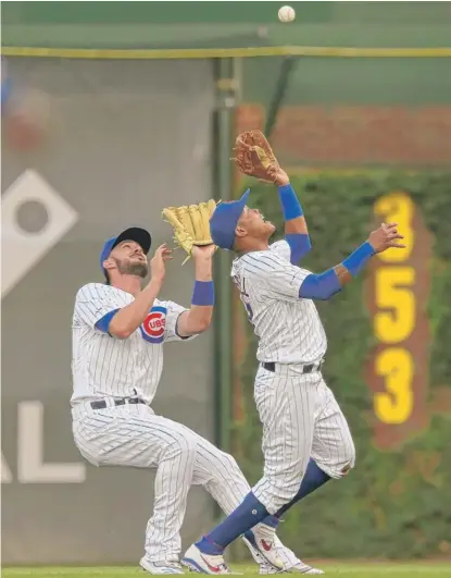  ?? AP ?? Addison Russell (right) catches a fly ball Monday while colliding with Kris Bryant. The Cubs committed 68 errors in the first half.