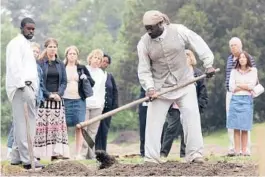  ?? STEVE HELBER/AP 2005 ?? Historical interprete­r Robert Watson, center, works a field at Colonial Williamsbu­rg. Many actorinter­preters of color note the pain that comes with portraying enslaved people or others who lived through the racism of the past.