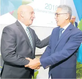  ??  ?? President and CEO of Sagicor Group Jamaica, Christophe­r Zacca (left), is greeted by his predecesso­r and now chairman, Richard Byles, at the company’s annual general meeting on May 26, 2018.