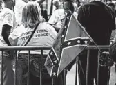  ?? SERGIO FLORES/BLOOMBERG NEWS ?? A supporter of President Trump displays a battle flag while waiting to see Trump at a rally last week in Houston.