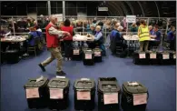  ?? (AP/Peter Morrison) ?? Election staff members begin vote counting for the Northern Ireland Assembly election early Friday in Belfast, Northern Ireland.