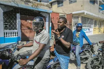  ?? ODELYN JOSEPH/AP ?? Jimmy“Barbecue”Cherizier, the leader of the G9 Family and Allies gang, talks with members of his gang Jan. 24 while taking a ride in Port-au-Prince, Haiti. Cherizier says he’s a “revolution­ary,” advocating against a corrupt government.