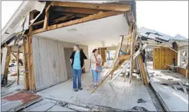  ?? GERALD HERBERT/AP ?? Lanie Eden and her husband, Ron, survey the damage at the vacation home they have rented for years in Mexico Beach. “Basically, we lost ‘old Florida.’ It’s all gone,” she said.