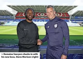  ?? ?? > Romaine Sawyers checks in with his new boss, Steve Morison (right)
