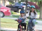  ?? DAVID ANGELL — FOR MEDIANEWS GROUP ?? Wearing bicycle helmets are Evan Mullins, 9, and his sister Avery, 11, during a ride along the sidewalk near their home in Macomb Township. Both kids enjoy riding their bikes with their dad Mark Mullins, who insists they wear a helmet.