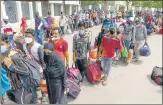  ?? PTI ?? Migrants wait to get on a bus that would carry them to a railway n station, in Ahmedabad on Friday.