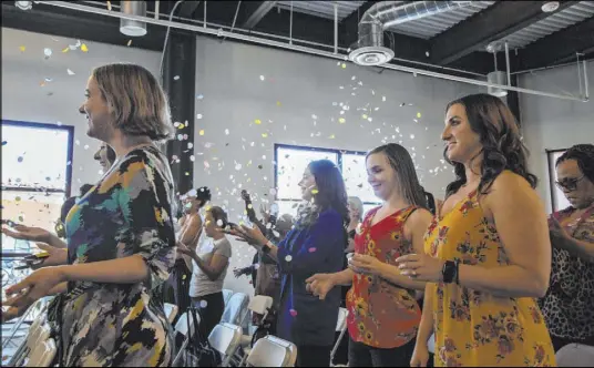  ?? Michael Blackshire Las Vegas Review-Journal ?? Attendees Kathryn Spada, 26, second from left, McKaylee Brown, 27, third from left, and Amanda Peraza, 30, right, all of Las Vegas, toss confetti during the Manifest Summit on Saturday at Tivoli Village.