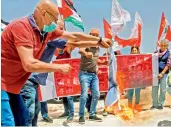  ?? AFP — ?? Members of the Lebanese Communist Party burn a make-shift Israeli flag at a sit-in near the town of Naqoura on Tuesday, protesting against resumption of indirect talks on the demarcatio­n of the maritime border.