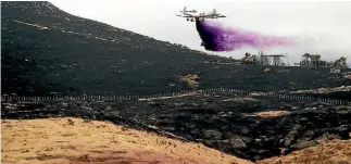  ?? PHOTO: JOSEPH JOHNSON/FAIRFAX NZ ?? Fire retardant is sprayed as work continues to dampen the fire on the Port Hills.